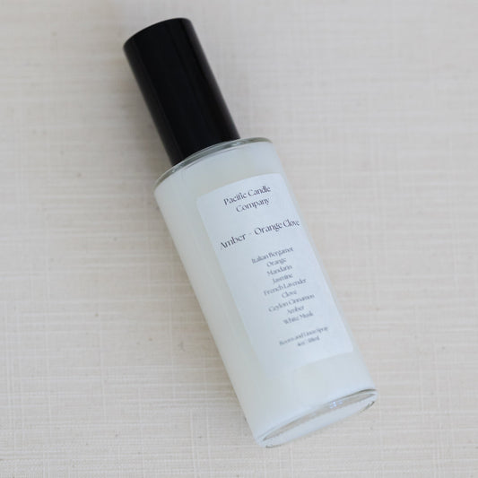 An eco-friendly room spray in a sleek amber glass bottle, made with clean, phthalate-free ingredients to refresh any space with a luxurious scent. Perfect for quickly creating a calming or uplifting atmosphere. Scent: Amber + Orange Clove