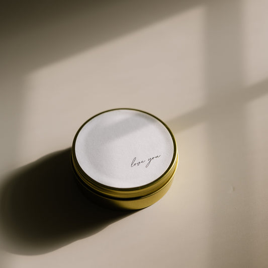 Love You. A travel-size soy candle in a stylish and reusable tin, hand-poured with clean, eco-friendly wax for on-the-go luxury. Ideal for gifting or bringing a cozy atmosphere to any space.