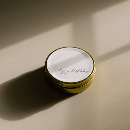 Happy Birthday. A travel-size soy candle in a stylish and reusable tin, hand-poured with clean, eco-friendly wax for on-the-go luxury. Ideal for gifting or bringing a cozy atmosphere to any space.