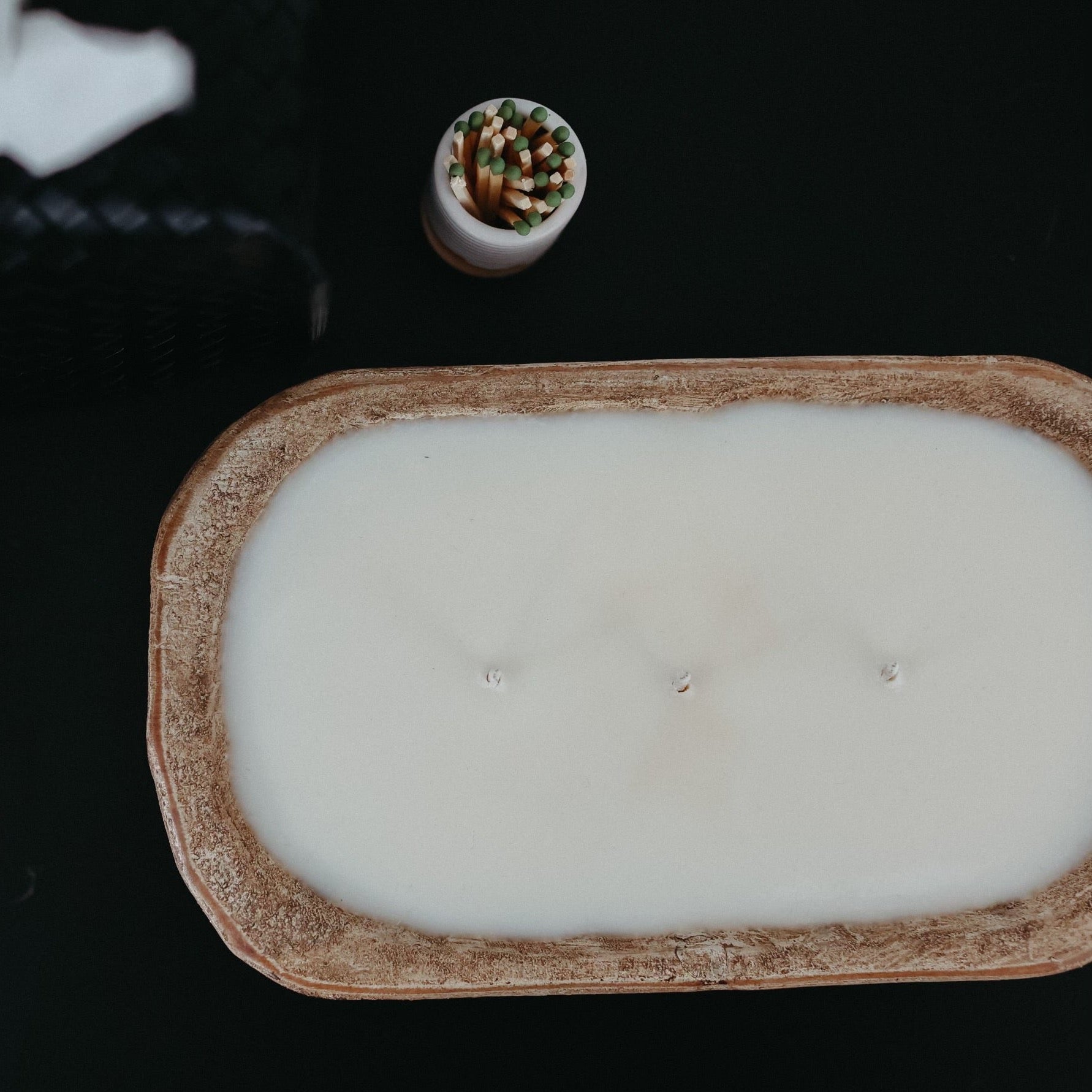 A rustic dough bowl candle made from hand-carved, sustainable wood, filled with creamy soy wax and multiple wicks for an inviting glow. A perfect statement piece for your home or a thoughtful gift. 