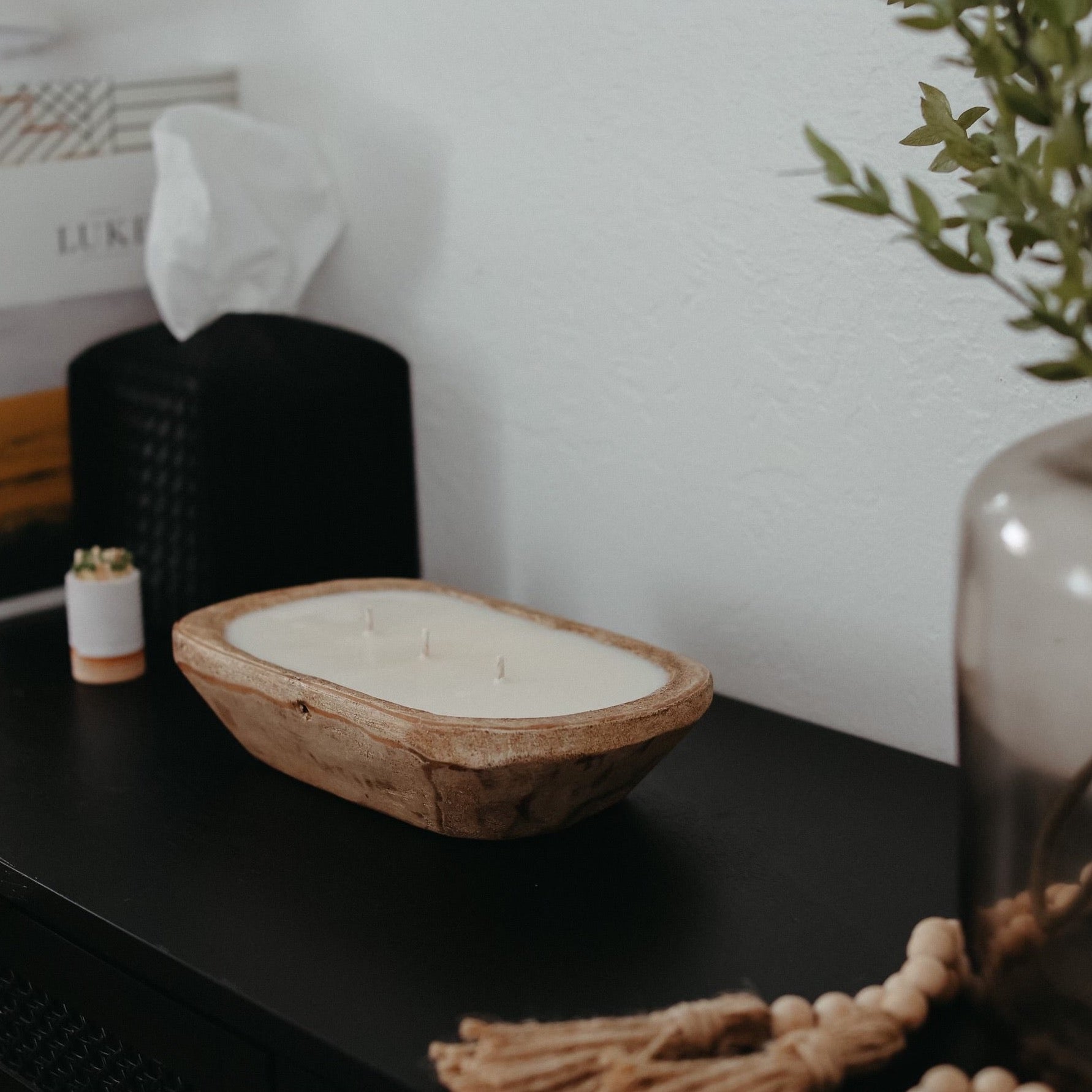 A rustic dough bowl candle made from hand-carved, sustainable wood, filled with creamy soy wax and multiple wicks for an inviting glow. A perfect statement piece for your home or a thoughtful gift. 